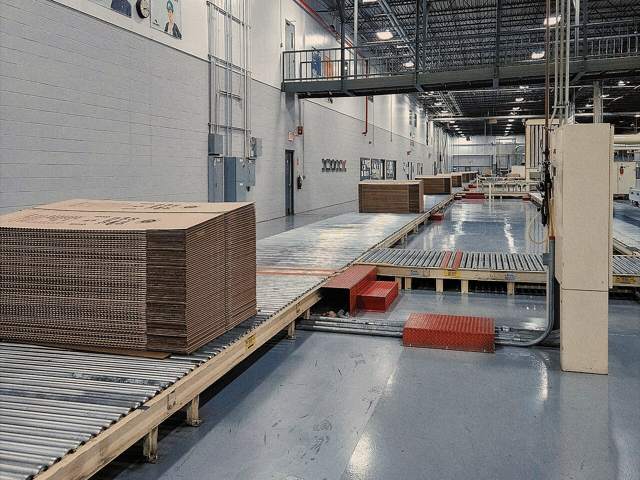 Corrugated board blanks on a conveyor in a converting plant (stock photo)